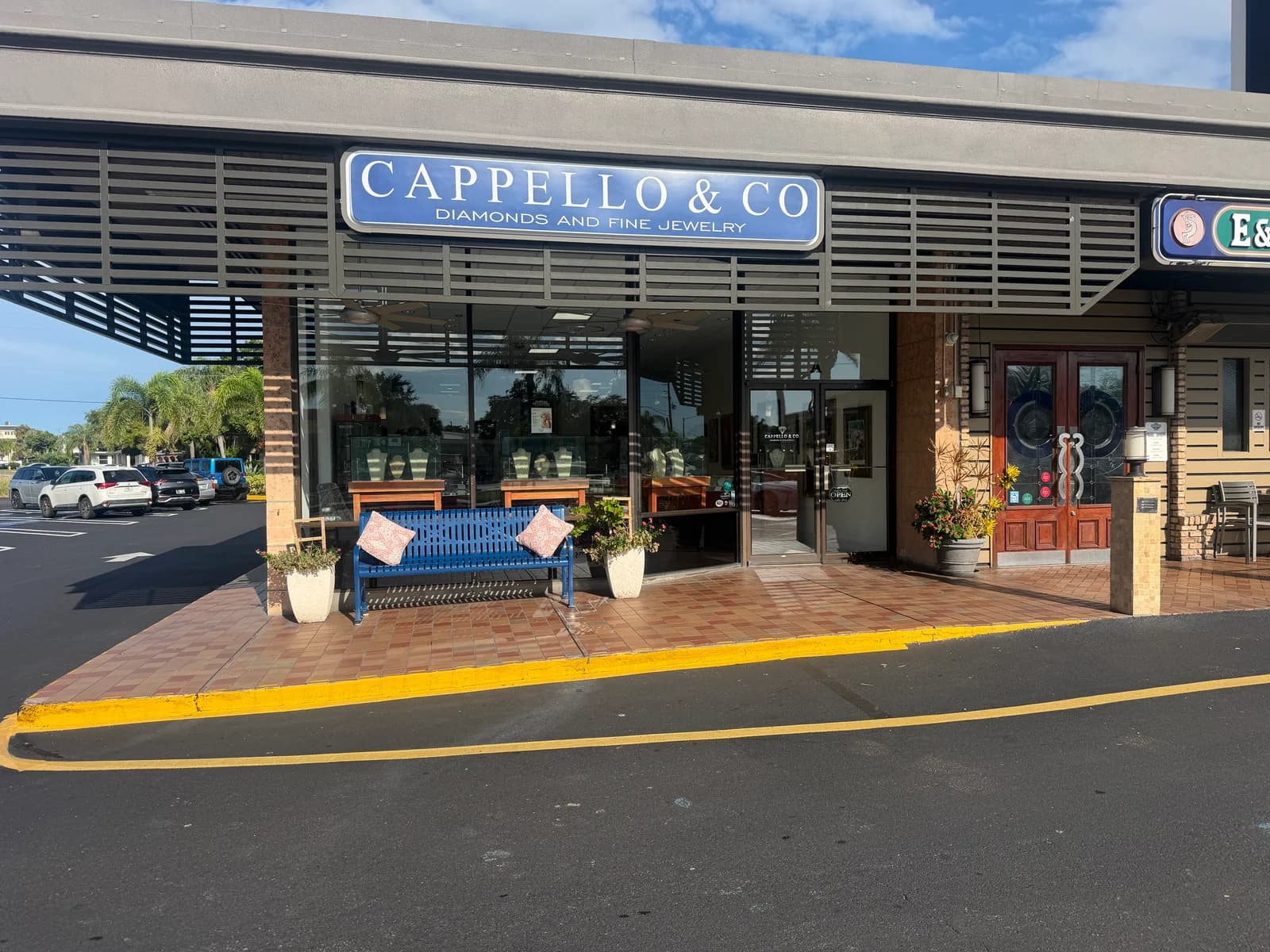 Cappello & Co storefront with blue sign and welcoming blue bench in Belleair Bluffs